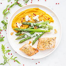 dinner in a ketogenic box diet - lemon salmon fillet, cauliflower and pumpkin purée with turmeric, green asparagus with parmesan shavings